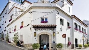 A white building with a sign reading "LA COLETA HOTEL" and a "HOTEL" sign above it. - Hotel La Goleta (Llanca)