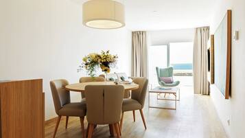 Un espace repas moderne avec une table ronde, des chaises et un vase de fleurs.