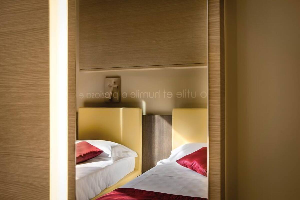 Une chambre d’hôtel avec deux lits, chacun doté d’une tête de lit et d’oreillers.