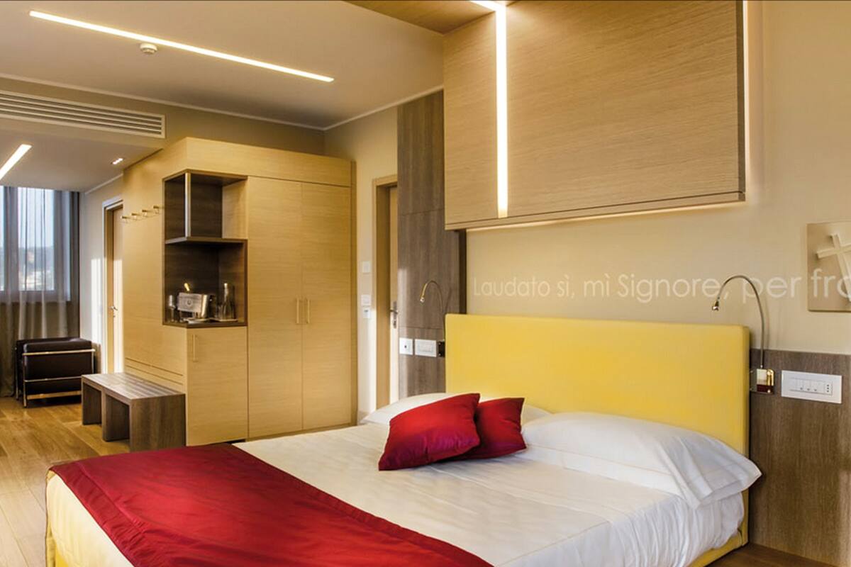 Une chambre à coucher moderne avec un lit, un banc et des rangements intégrés.