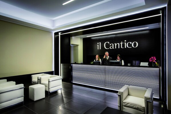 A reception area with a black and white striped counter, white seating, and a sign reading "il Cantico". - Hotel Il Cantico St. Peter (Rome)