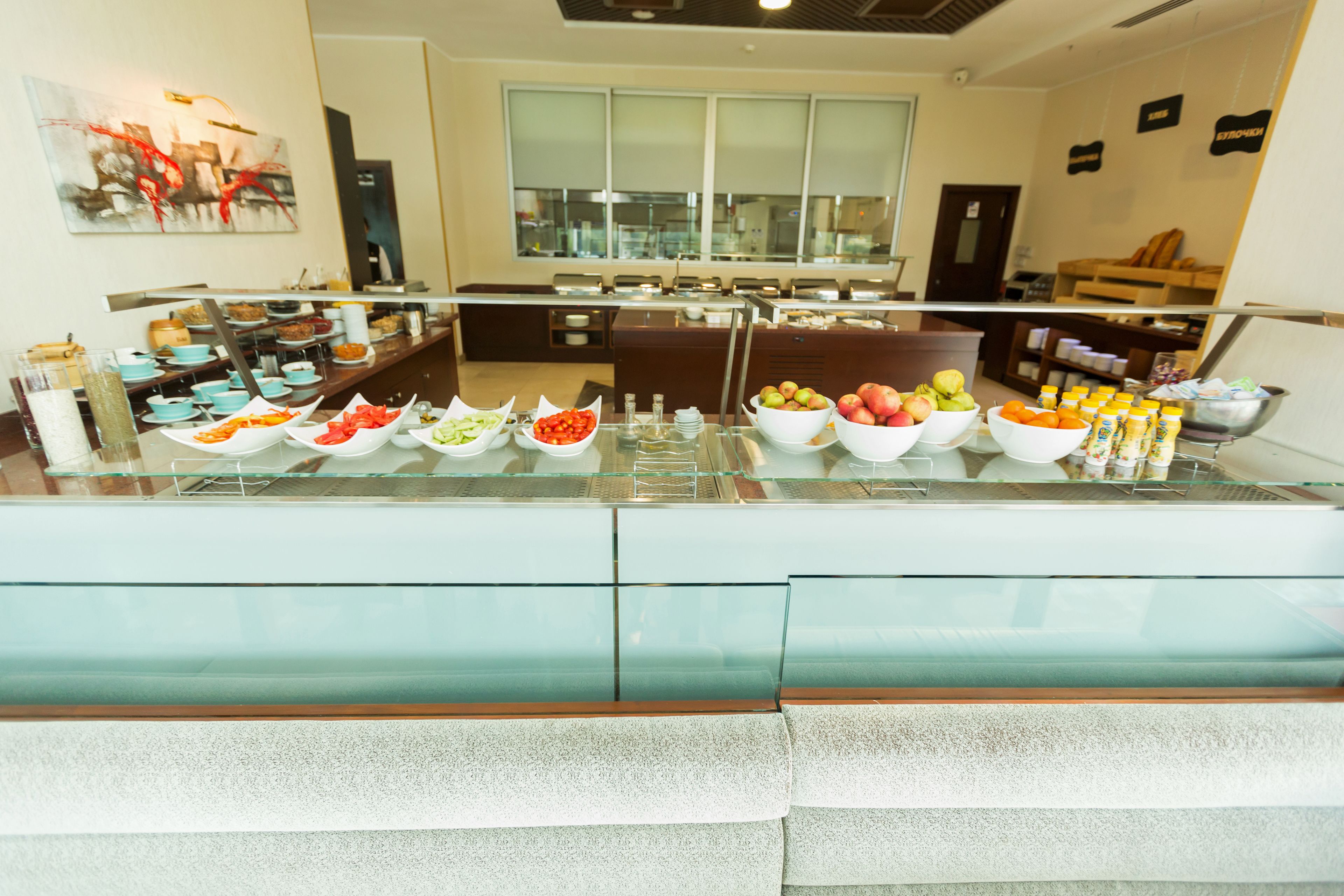A buffet area with various food items and a seating area in the background.