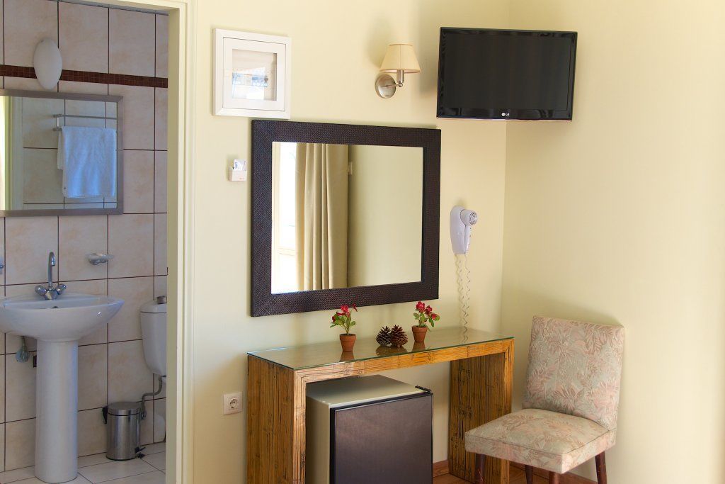 A bathroom with a sink, mirror, and a small table with decorative items.