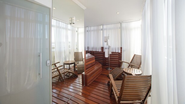 A sunlit room with wooden flooring, a bench, and several wooden chairs. - Faro Hotel São José dos Campos (São José dos Campos)