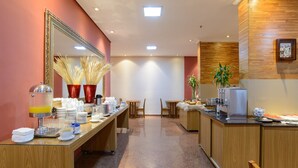 A hotel lobby with a reception desk, chairs, a buffet area, and a large mirror. - Faro Hotel São José dos Campos (São José dos Campos)