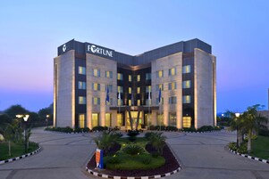 Un edificio moderno con el nombre "FORTUNE" en la fachada, que presenta un diseño simétrico con varios pisos y una entrada central.