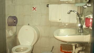 Un baño con inodoro, lavabo y barra para toallas.