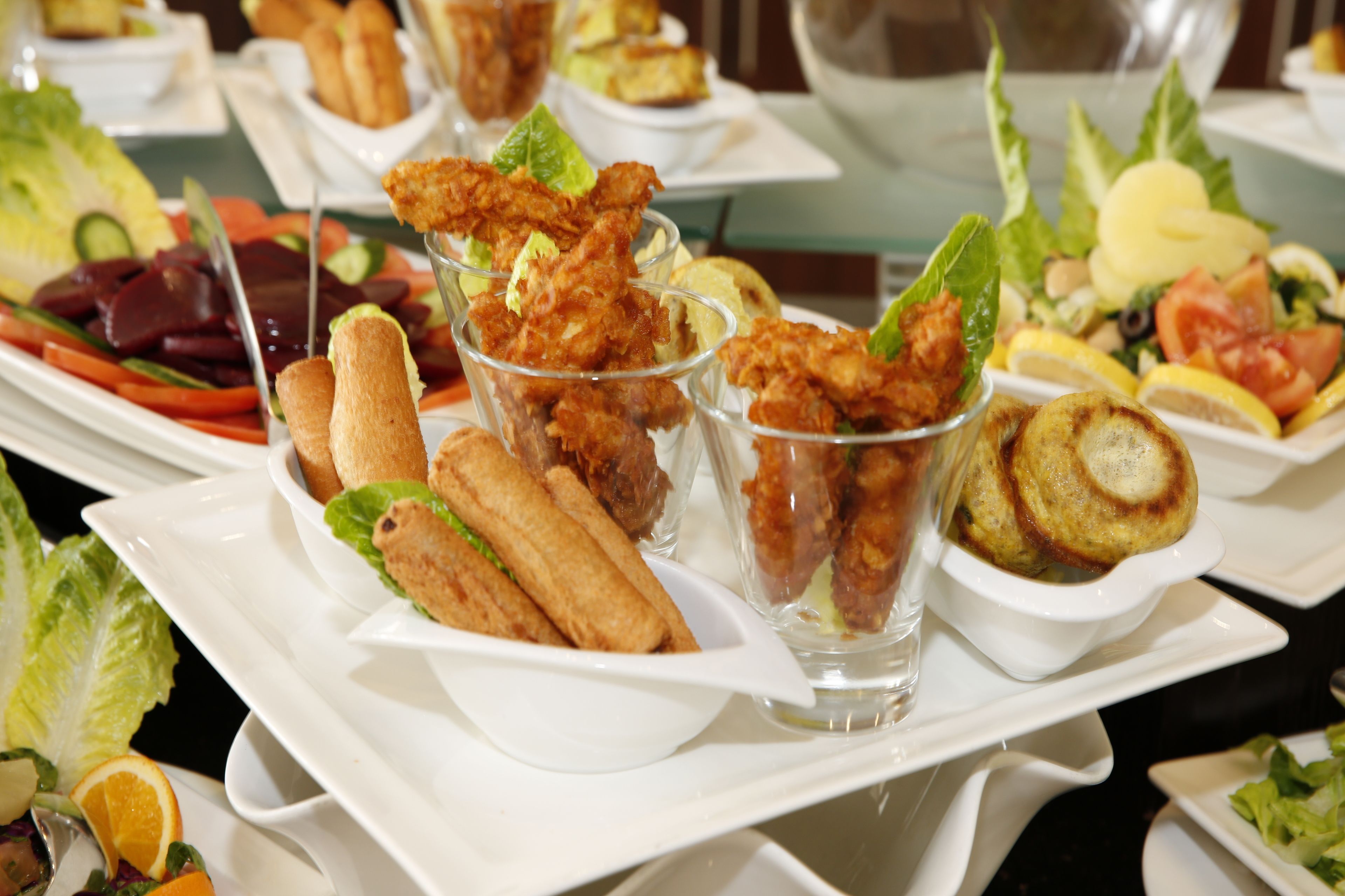 A buffet with various dishes including fried items, salads, and bread.