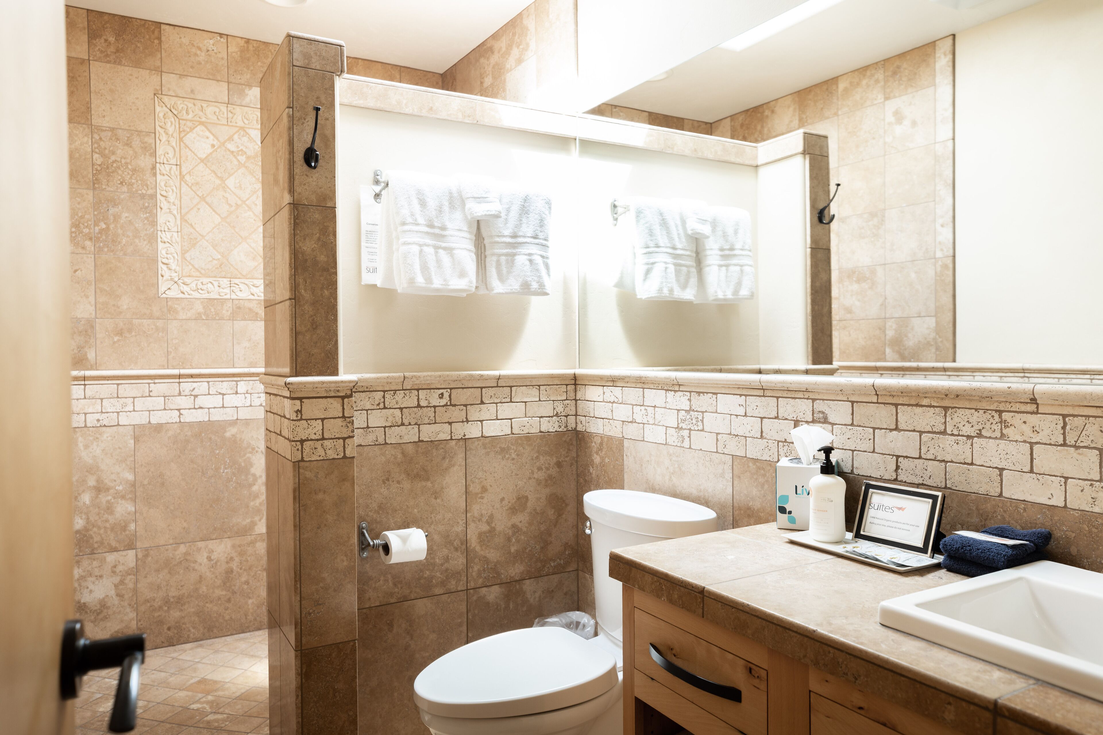 A bathroom with a toilet, sink, and shower area.