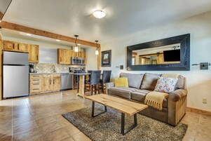 Une cuisine moderne avec des meubles en bois, un réfrigérateur en acier inoxydable et un coin repas comprenant une table et des chaises.