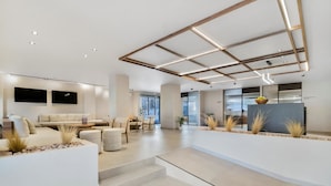 Una sala moderna con sofá, comedor y zona de cocina.