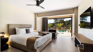 Habitació d'hotel moderna amb un llit gran, un ventilador de sostre, una televisió i un balcó amb vista a la piscina.