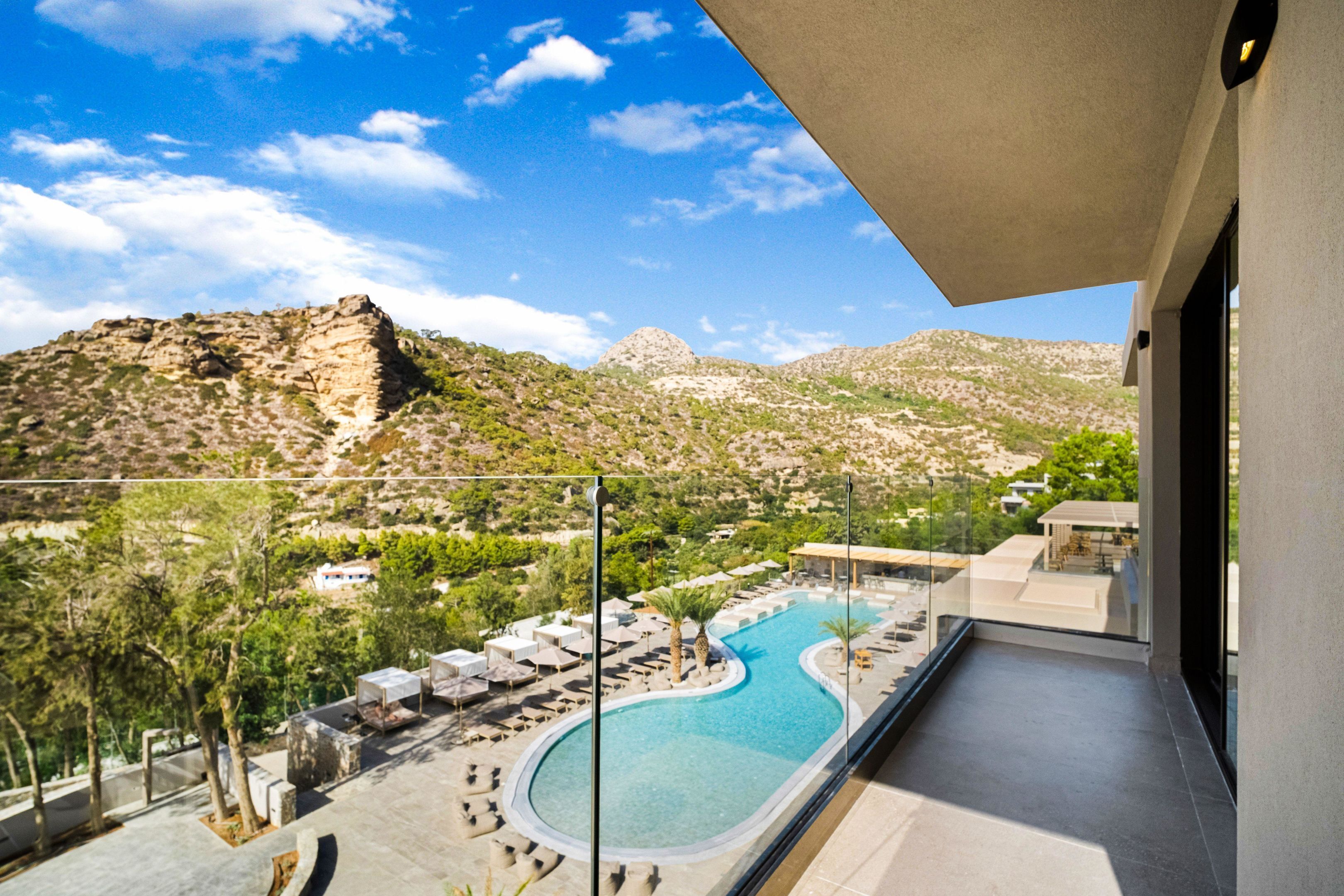 Un área de piscina con sillones de descanso y vistas del paisaje circundante.
