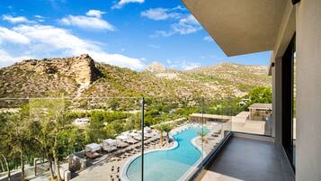 Un área de piscina con sillones de descanso y vistas del paisaje circundante.