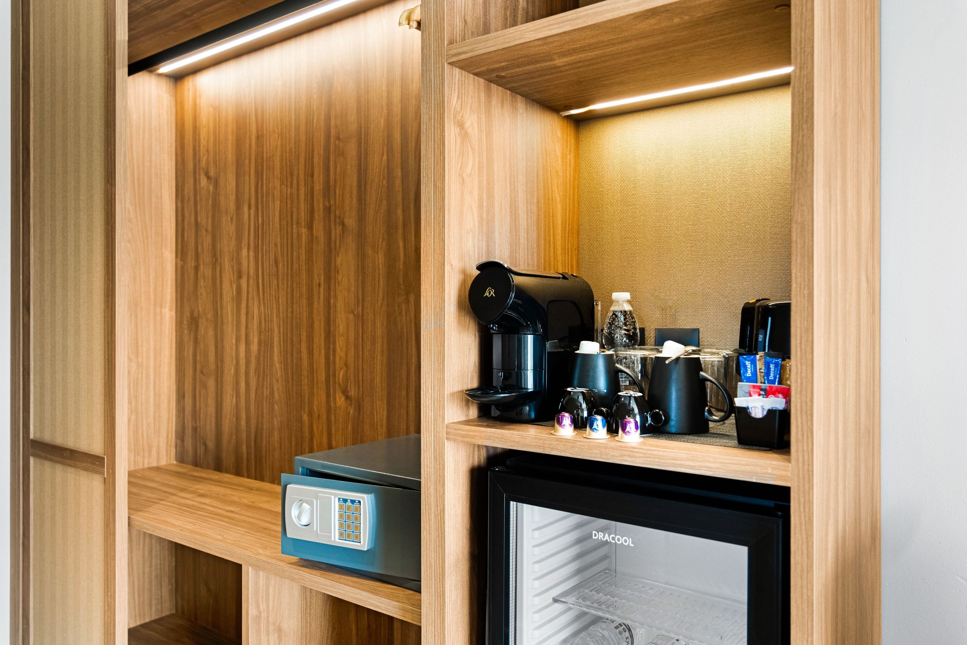 A compact kitchenette with a coffee maker, a mini-fridge, and a microwave.