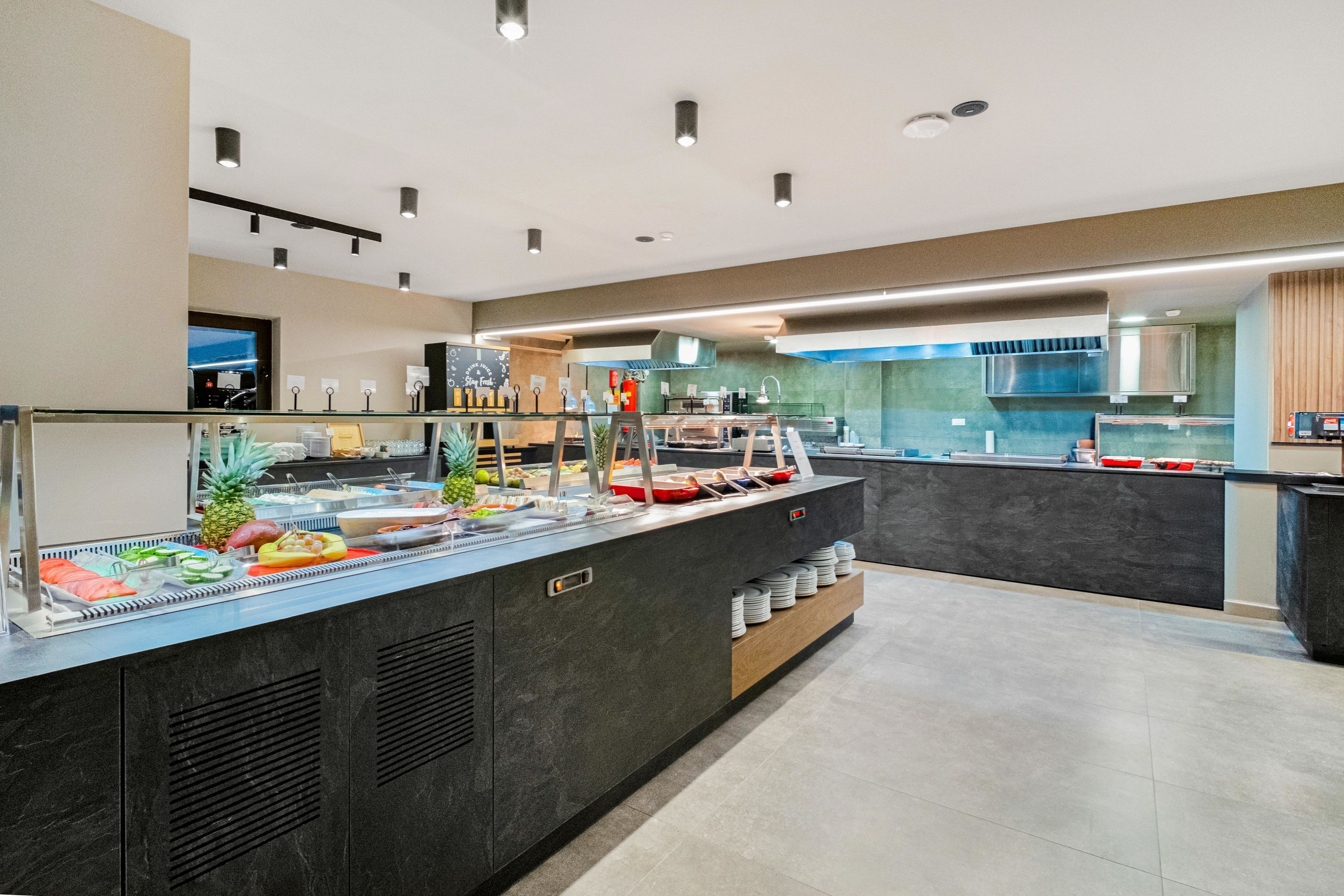 Un espace buffet proposant une variété de plats, avec une cuisine en arrière-plan.
