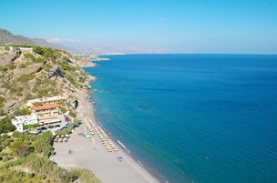 Una playa cerca, sillas reclinables de playa, sombrillas