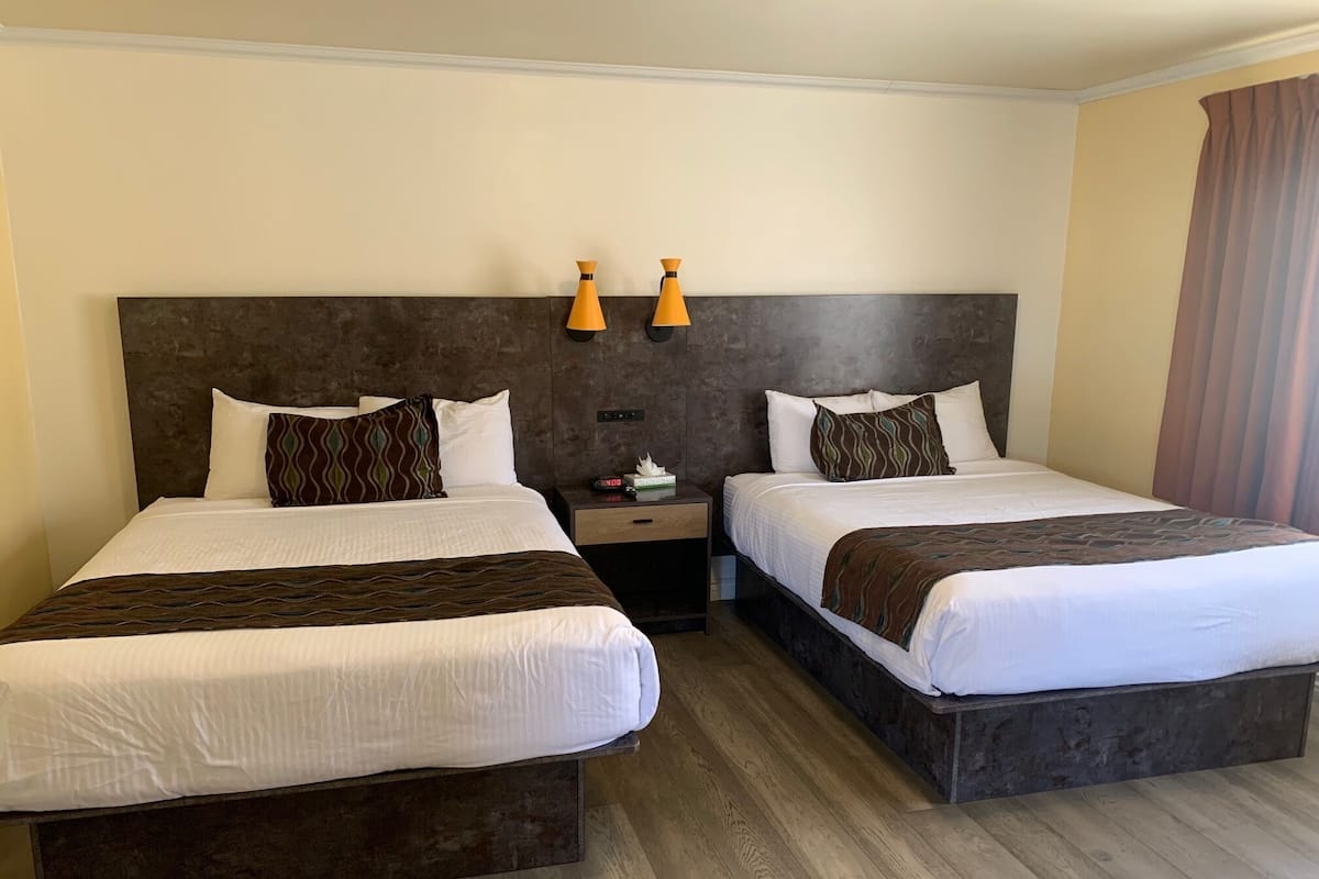Habitación, 2 camas Queen size | Tabla de planchar con plancha, wifi gratis y ropa de cama