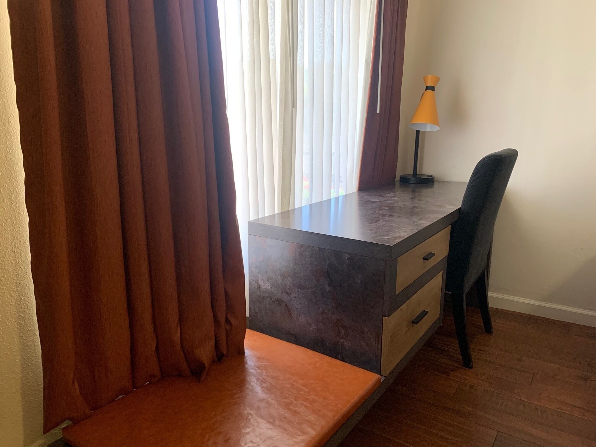 Une pièce comprenant un bureau, une chaise et un banc.