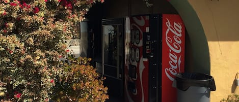 A Coca-Cola vending machine under an archway with a sign that reads "ICE".