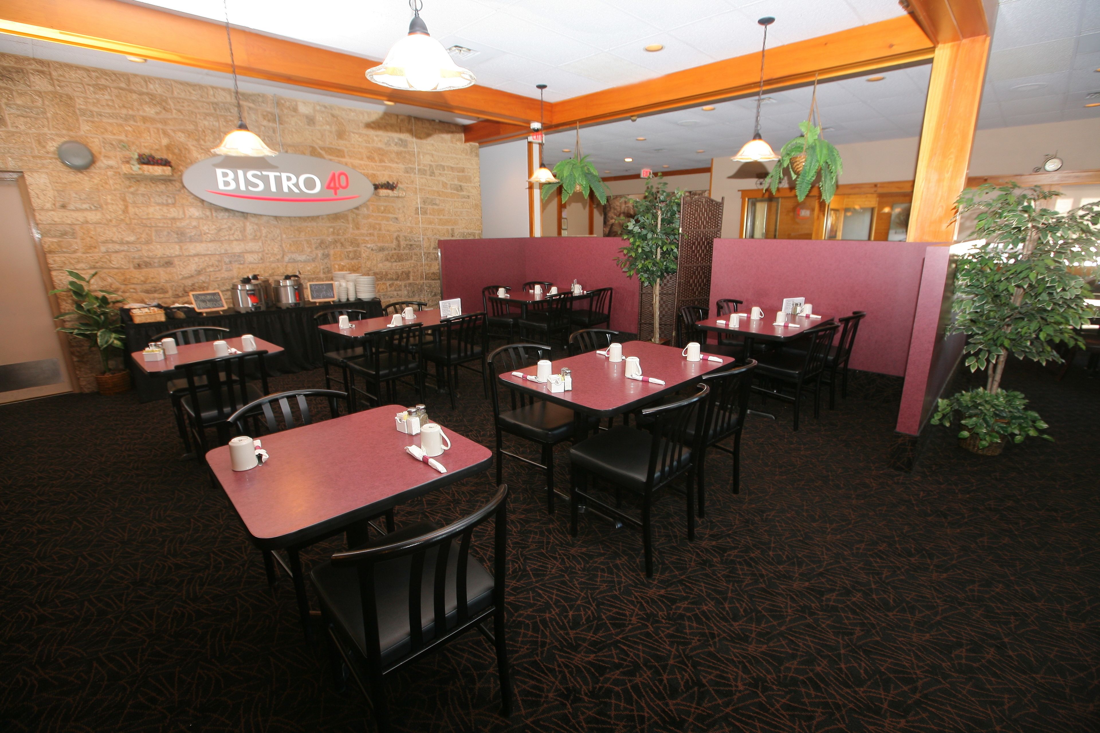 A restaurant interior with tables and chairs, a stone wall, and a sign that reads "BISTRO 40".