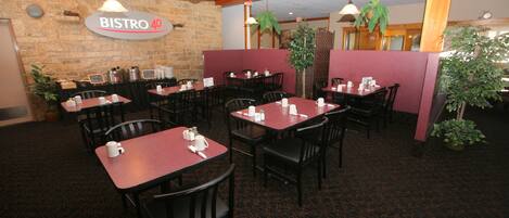 A restaurant interior with tables and chairs, a stone wall, and a sign that reads "BISTRO 40".