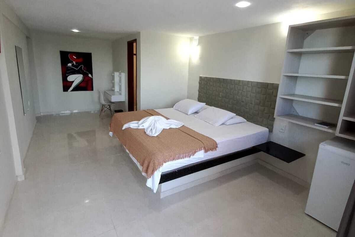 Ein modernes Schlafzimmer mit Bett, Nachttischen, einem Kleiderschrank und einem an der Wand befestigten Regal.
