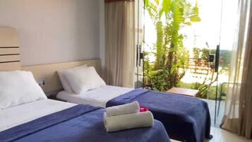 Quarto triplo conforto, vista para o mar | Frigobar, roupa de cama