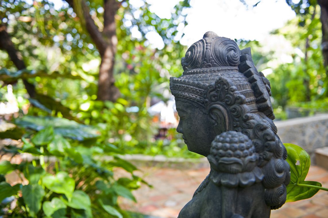 Una estatua con tallas intrincadas en un jardín.