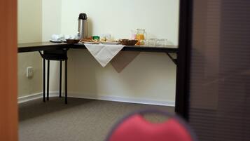 A breakfast table with a coffee pot, juice pitcher, and various breakfast items.
