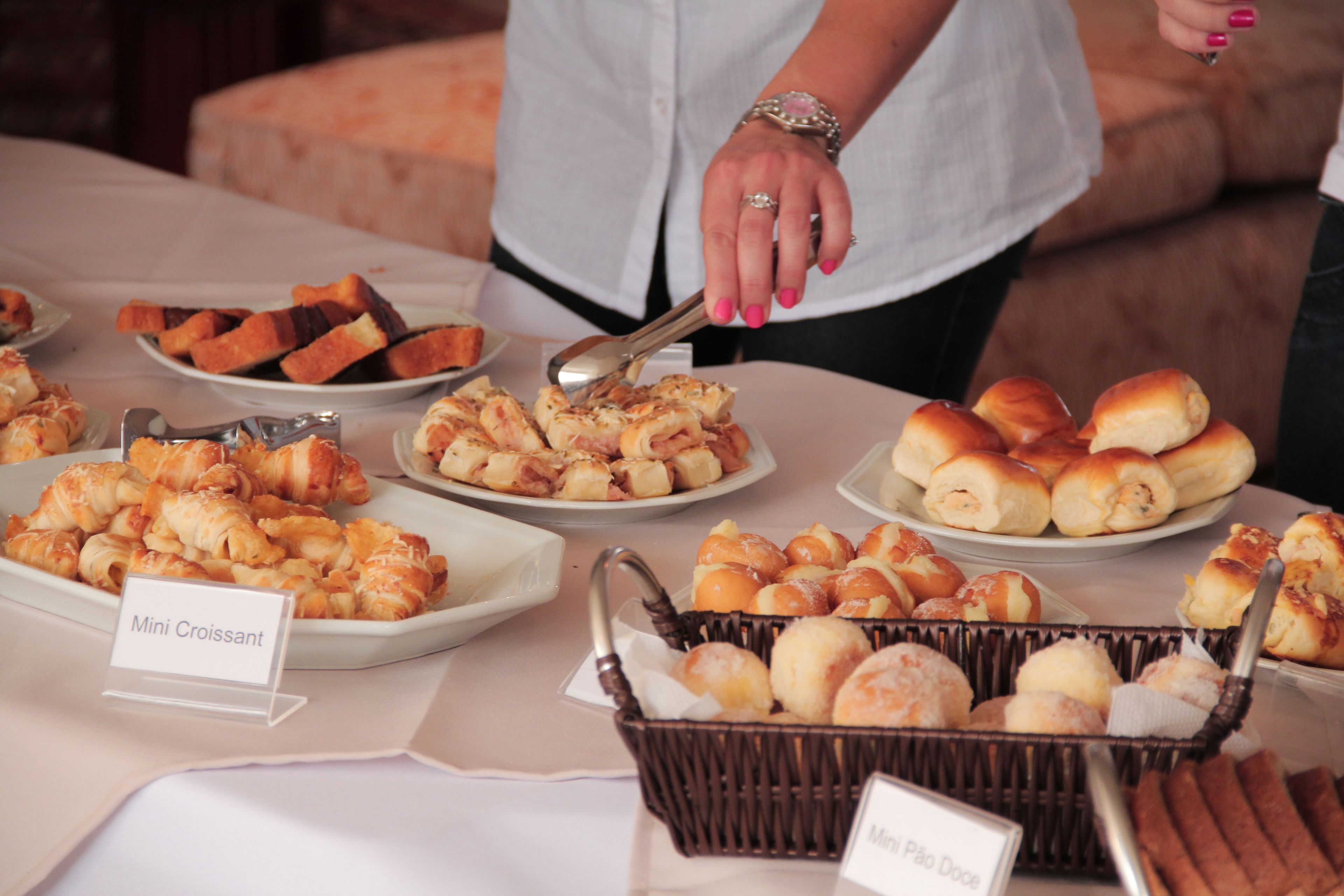 A buffet table with various pastries and a sign indicating 'Mini Croissant'.