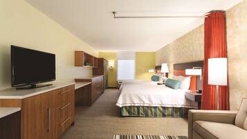 A hotel room with a bed, a TV, a desk, and a sofa.