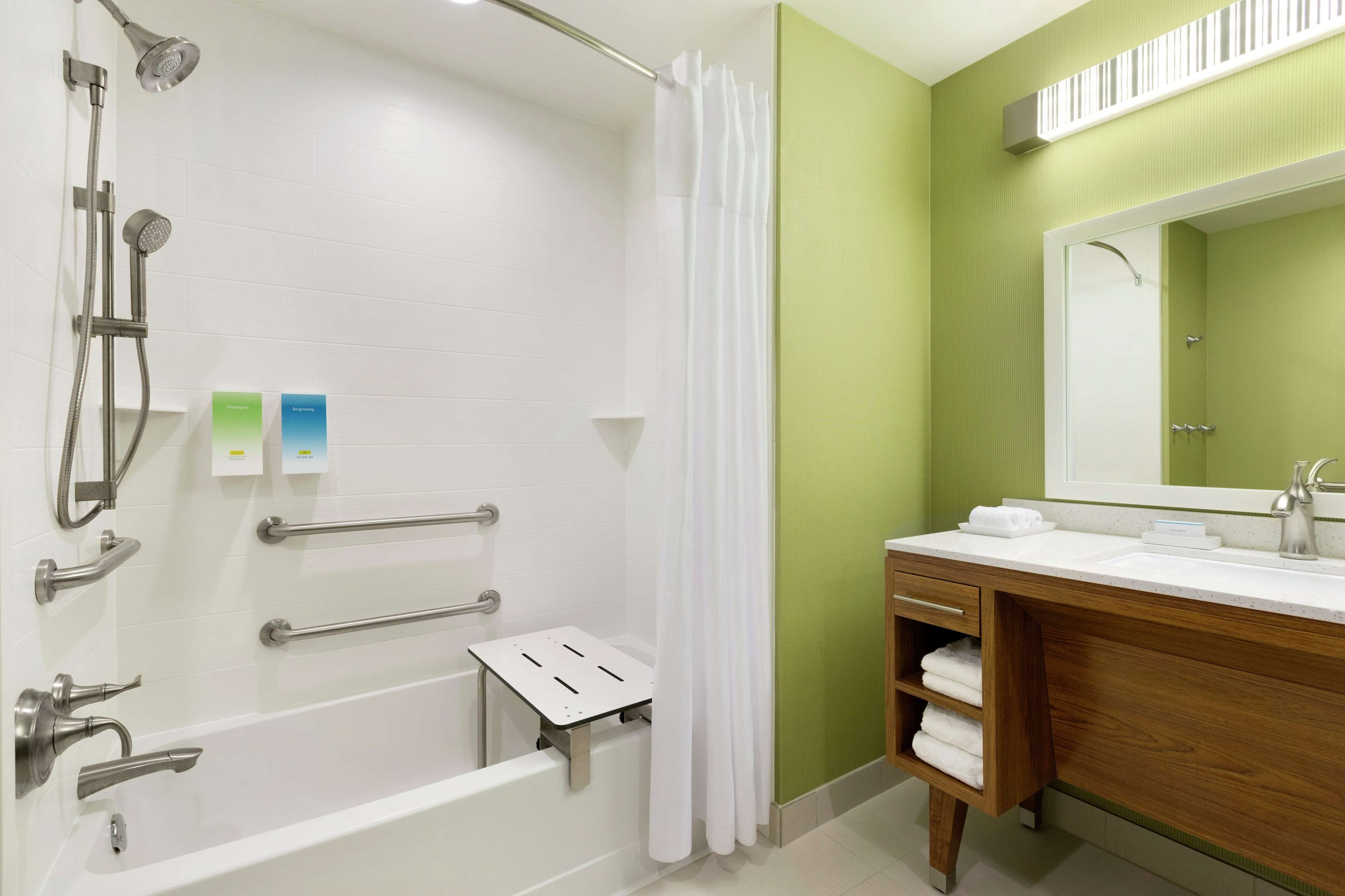 Un baño moderno con bañera, ducha y tocador con espejo.