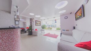 Un intérieur moderne comprenant un comptoir d’accueil, un espace détente et une vue sur la rue.