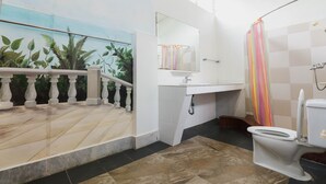 A bathroom with a toilet, sink, and shower. There is a staircase with a railing leading to a balcony with plants. - KokosNuss Garden Resort (Coron)