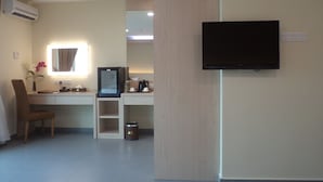 A hotel room with a desk, chair, TV, air conditioning unit, and a small trash bin. - Midcity Hotel Melaka (Malacca City)