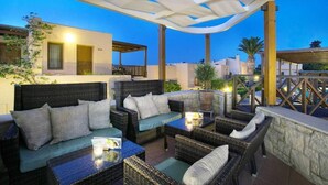 An outdoor seating area with wicker furniture and a covered section. - Ida Village I & II (Hersonissos)