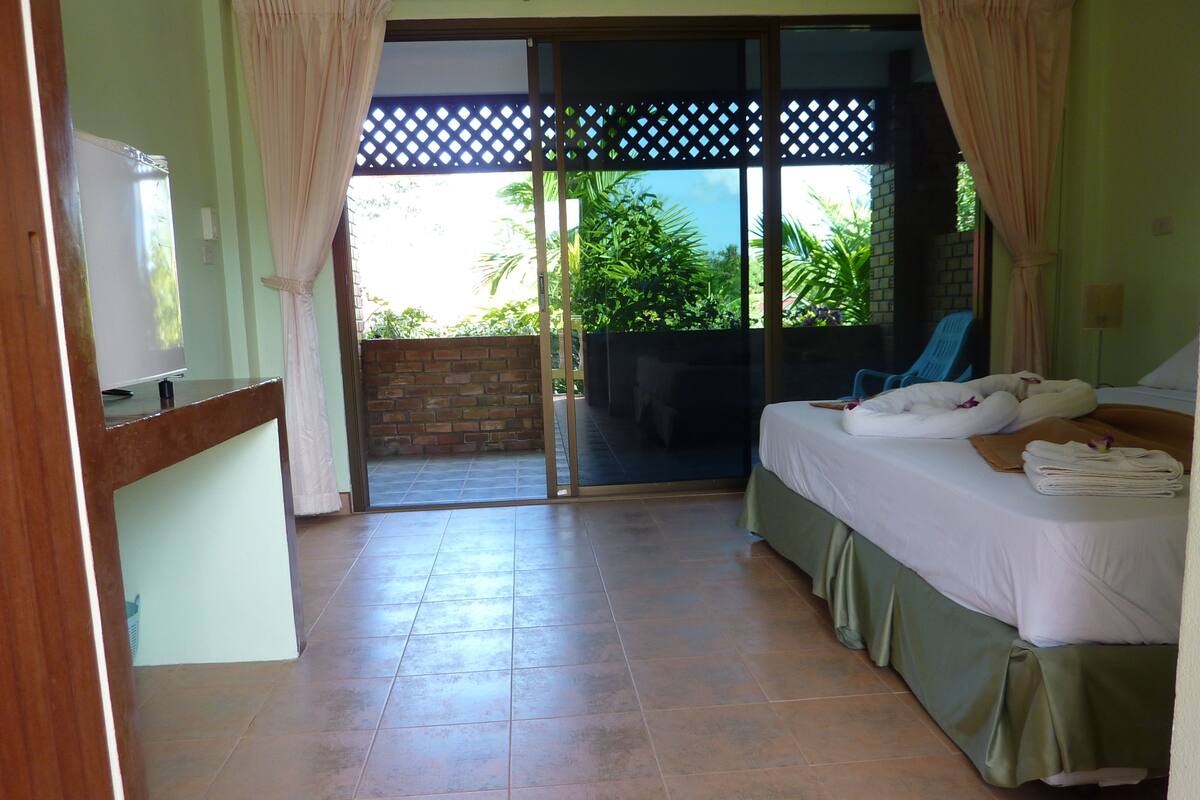 Quarto de hotel com uma cama, uma mesa e vista para o exterior.