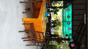 A dining area with a long wooden table and chairs, surrounded by a green wall with circular decorations. - Ladda Resort (Takua Pa)