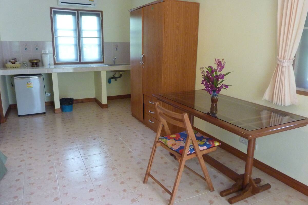 Cozinha compacta com geladeira, pia e janela.