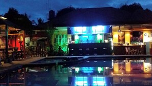 A hotel with a pool, outdoor seating, and a bar area. - Citadel Bed and Breakfast (Puerto Princesa)