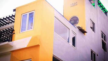 A building with a yellow facade and a purple section, featuring a number '1925' on the purple part.