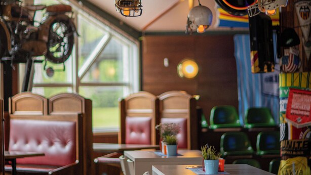A restaurant interior with booths, a bar area, and a Guinness sign.