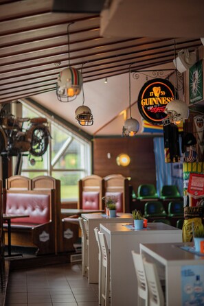 Interior de un restaurante con cabinas, una zona de bar y un letrero de Guinness.