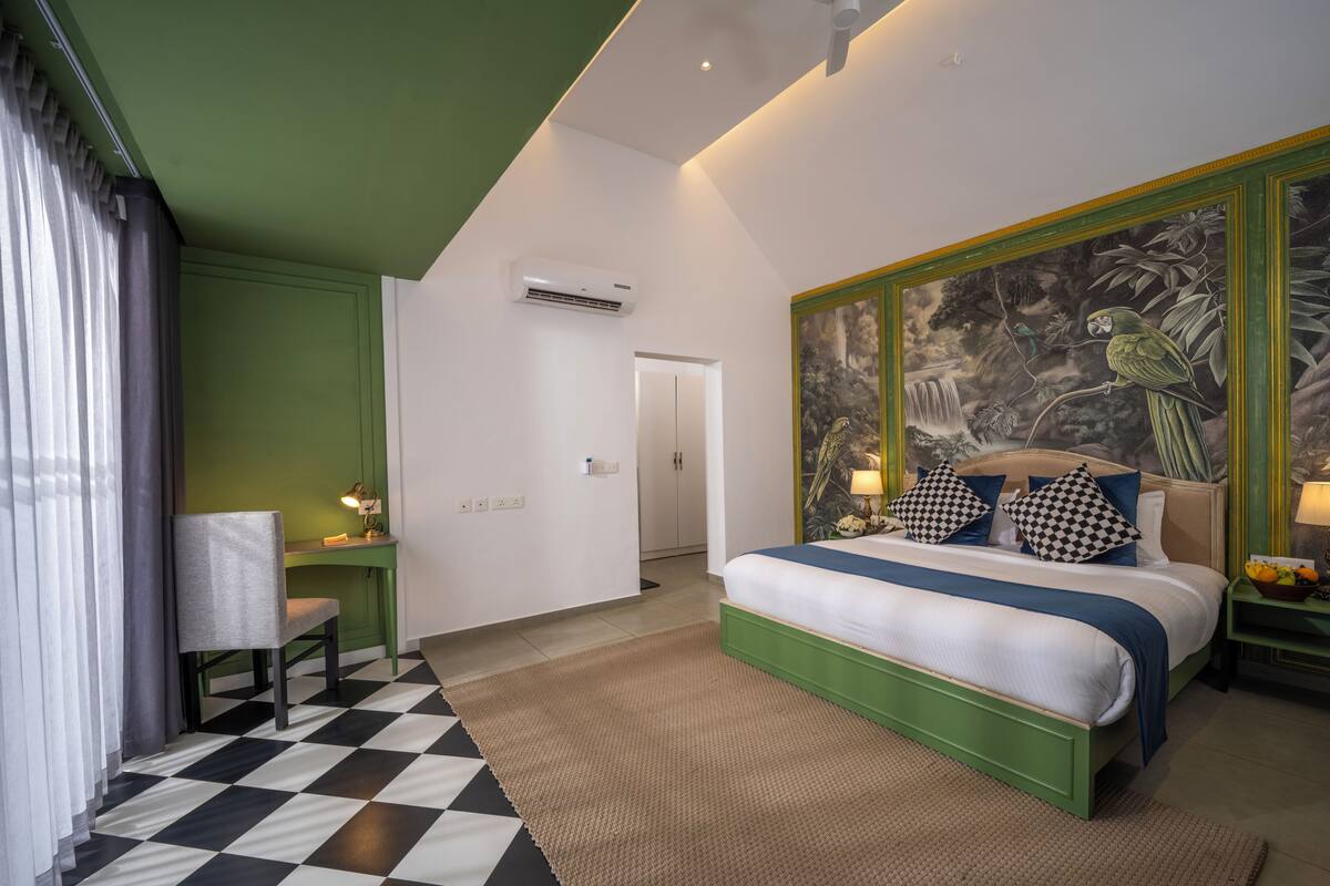Un dormitorio con cama, escritorio, silla y pared decorada con un mural.