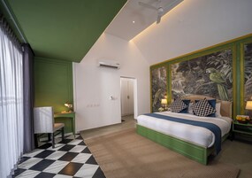 Quarto com cama, escrivaninha, cadeira e parede com mural.