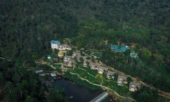 An aerial view of a residential area with houses, a small waterfall, and a bridge.