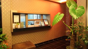 A reception area with a counter, framed certificates, and a potted plant. - Morice Hotel (Gwangyang)