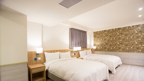 A hotel room with two beds, wooden headboards, bedside lamps, and a patterned wall. - Rainbow Hotel (Taipei)