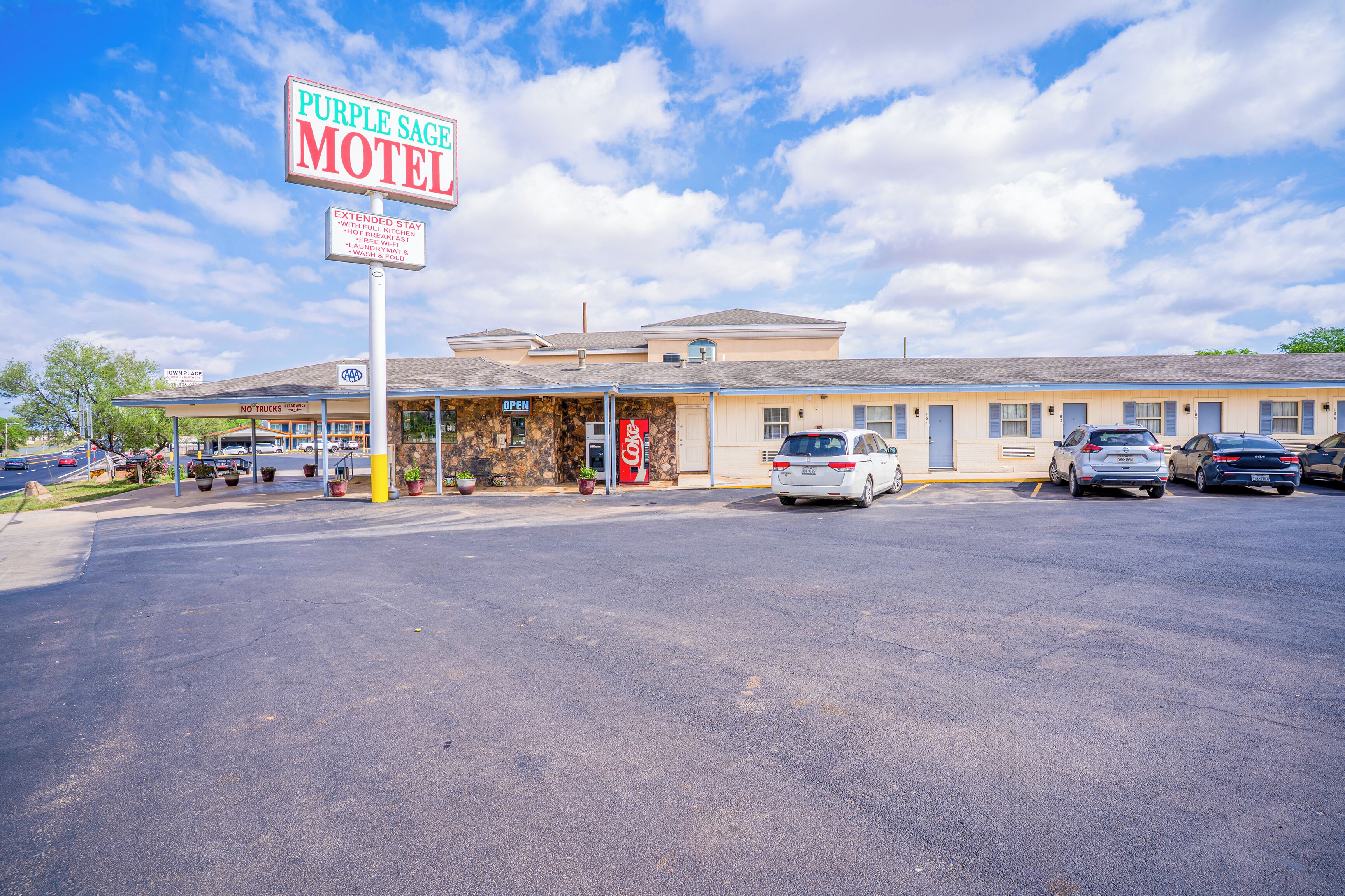 A motel with a sign reading "Purple Sage Motel" and a "No Trucks" sign.